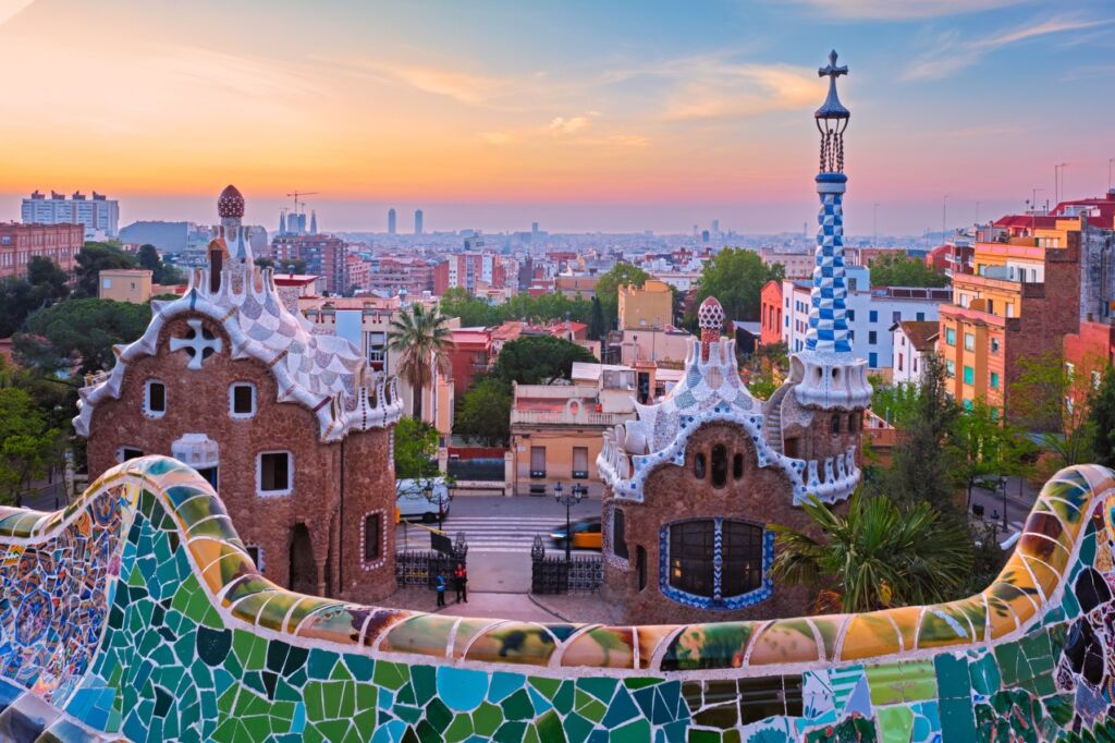 Barcelona city view from Guell Park with colorful mosaic buildings in the morning on sunrise. Barcelona, Spain